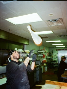 Tossing pizza dough in the kitchen