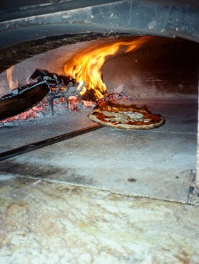 Pizza baking in the wood-fired oven